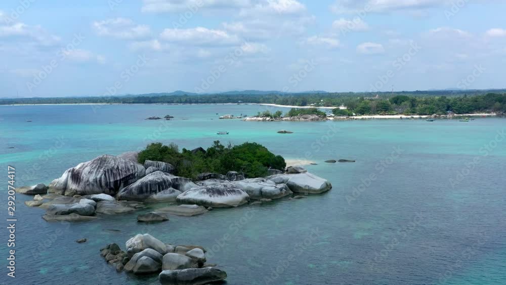 Aerial drone view above tropical island of tanjung kelayang belitung, white sandy beach with wooden boat and clear ocean water. Aerial drone view above tropical island of tanjung kelayang belitung, white sandy beach with wooden boat and clear ocean water.