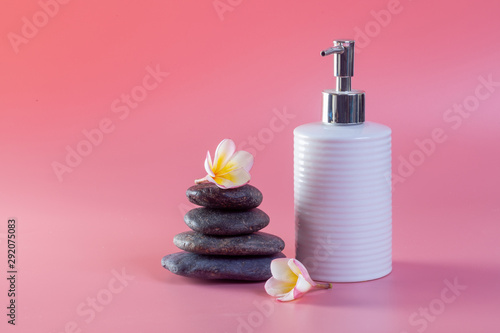 Spa cosmetics. Plumeria flowers on a pink background.