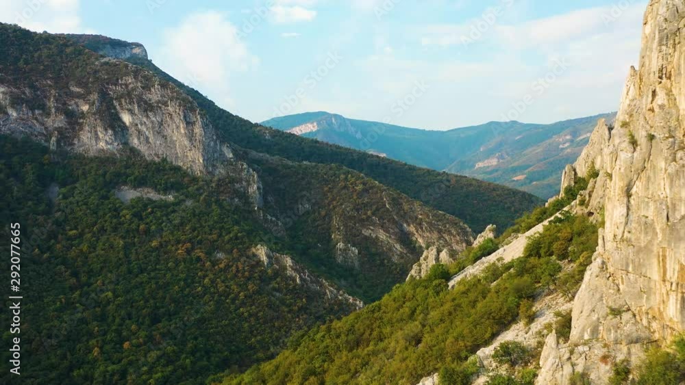 Aerial flyby backwards in mountain range discover rocky steep peaks Aerial flyby backwards in mountain range discover rocky steep peaks