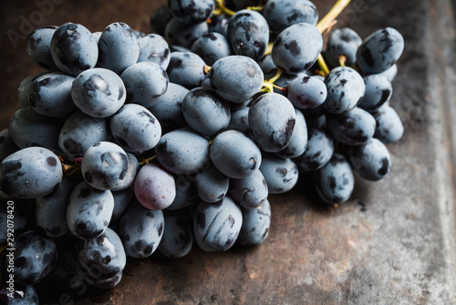Ripe black grape on the rustic background. Selective focus. Shallow depth of field.