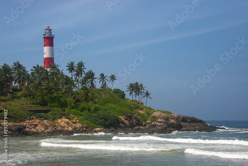 Lighthouse red and white tower and waves of the Arabian Sea in Kovalam  Kerala  India
