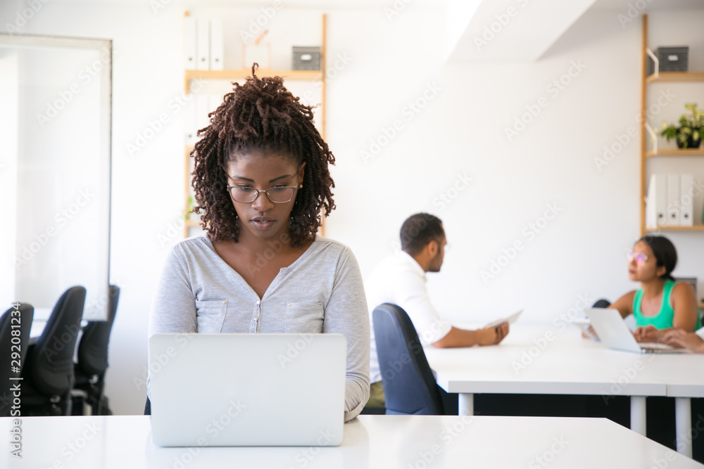 Serious excited African American employee working on computer in office ...