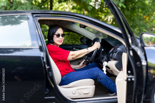 Happy senior woman in sunglasses driving a car. © bignai