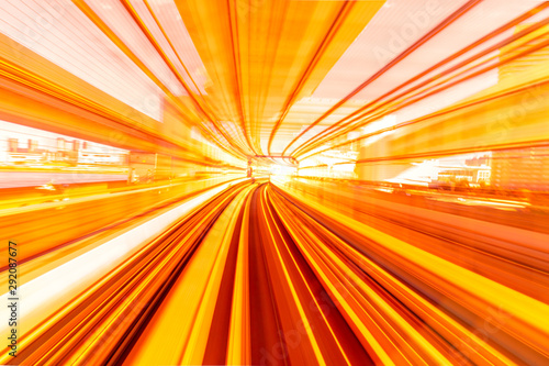 Motion blur of speed train moving in tunnel with light at end.
