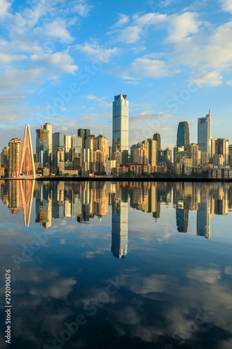 Chongqing skyline and modern urban skyscrapers with water reflection at sunset China.