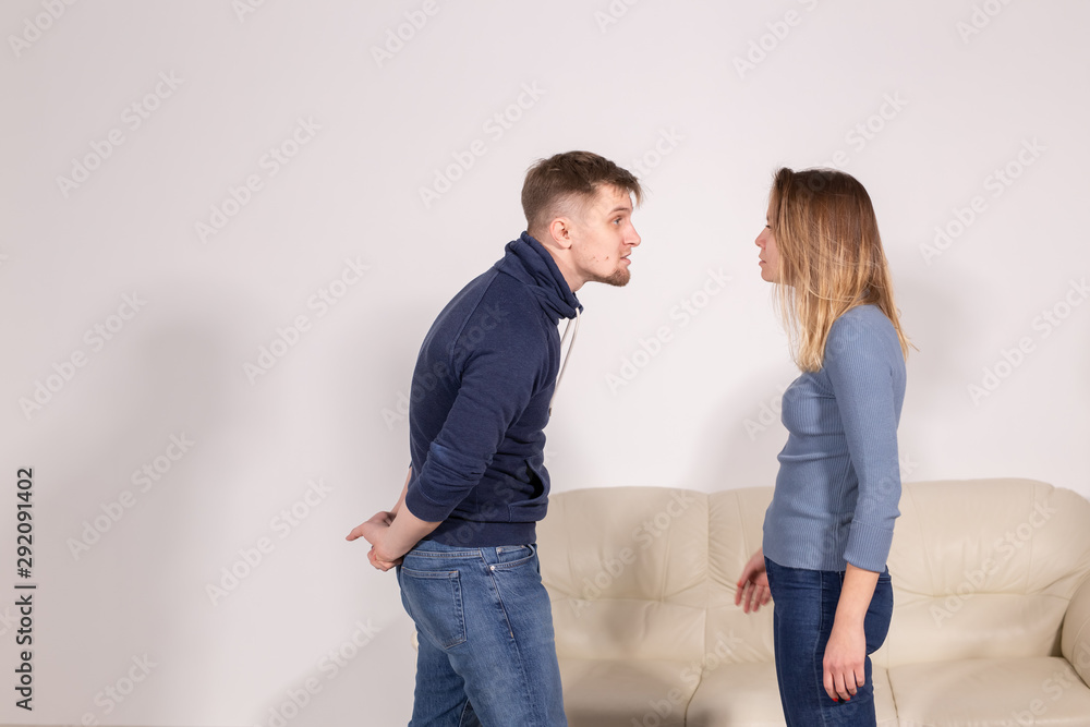 people, home violence and abuse concept - young couple screaming to each other people, home violence and abuse concept - young couple screaming to each other