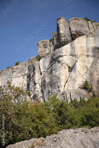 The vertical cliffs of the stone of Bismantova with blue sky in the background. Emilia Romagna, Italy. Vertical shot.