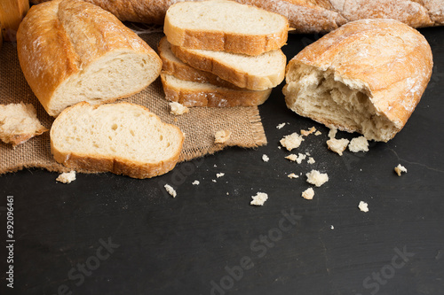 Fresh loaves of bread And sliced ​​bread Placed on a black stone table top view