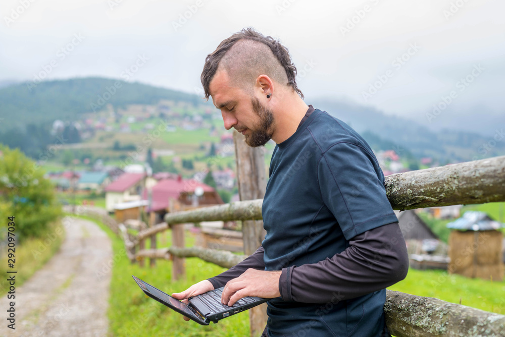 Remote work concept: a man working on a laptop outdoors. Remote work concept: a man working on a laptop outdoors.