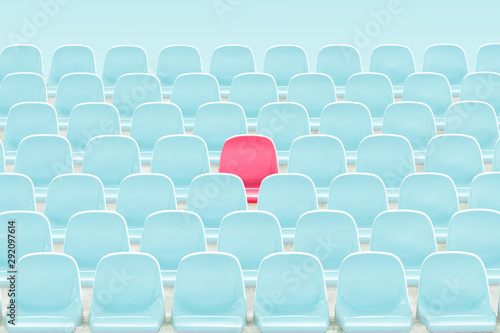 SInger red seat in the middle of light blue chair in stadium .