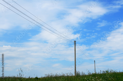 Telegraph poles in the summer meadow © chembarisovstudio