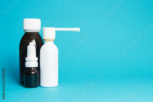 Treatment of colds and flu. Various medicines, sprays from a stuffy nose and a pain in a throat on a blue background. Copy space.