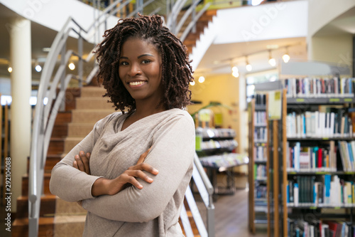 Canvas Print Cheerful smiling woman posing at public library