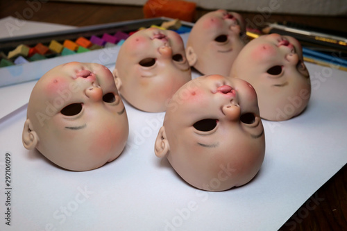 Making dolls. Heads of dolls are on the table by artist doll master for further processing. Close-up.