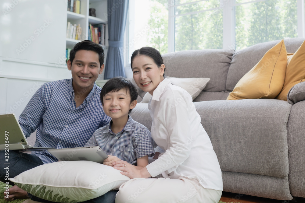 Asian family father, mother and son playing laptop computer together in living room, happy family concept Asian family father, mother and son playing laptop computer together in living room, happy family concept