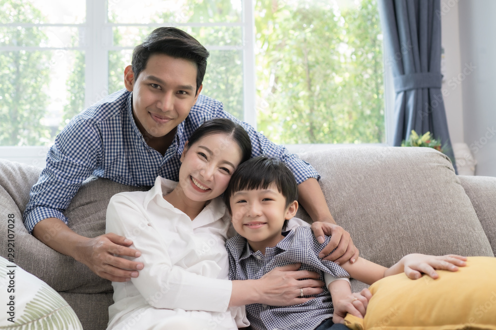 Asian family father, mother and son smiling together in living room, happy family concept Asian family father, mother and son smiling together in living room, happy family concept