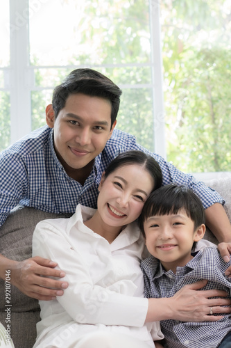 Asian family father, mother and son smiling together in living room, happy family concept