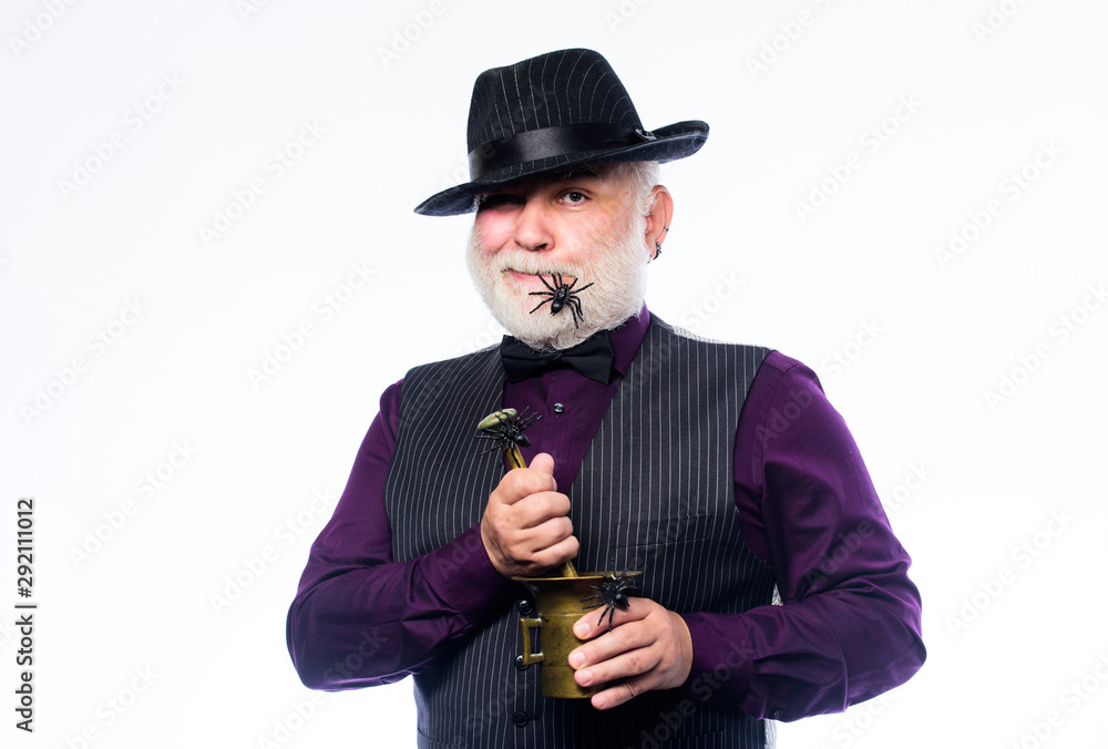 A real witch in disguise. mature man magician in witch hat. barman make  cocktail for halloween party. evil wizard cooking magic potion with spider.  halloween holiday costume. happy halloween Stock Photo