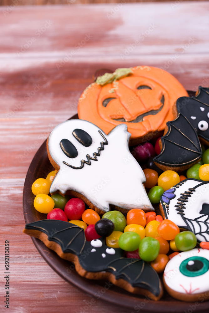 Halloween party content. Halloween gingerbread cookies on a wood background.