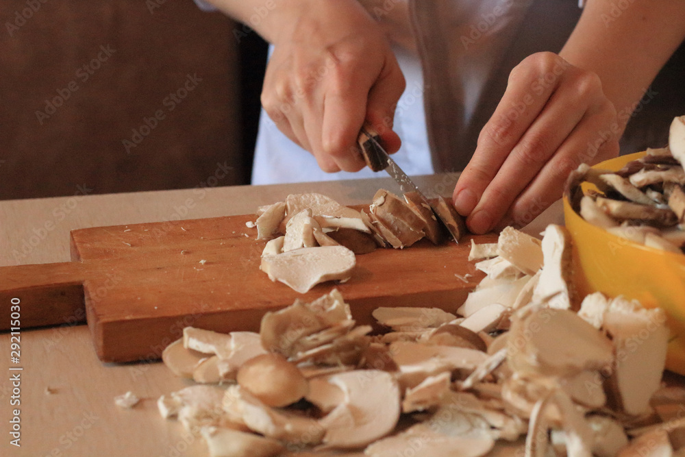 woman's hand cutting mushrooms in kitchen woman's hand cutting mushrooms in kitchen