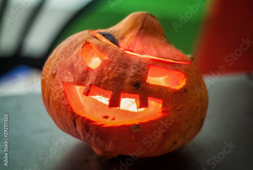 Citrouille orange d'Halloween lanterne en forme de tête sur fond vert