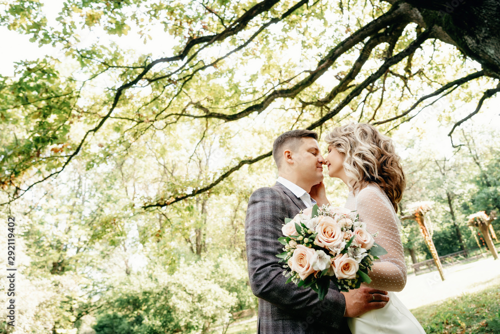 Portrait of kissing couple in the garden against huge oak Portrait of kissing couple in the garden against huge oak
