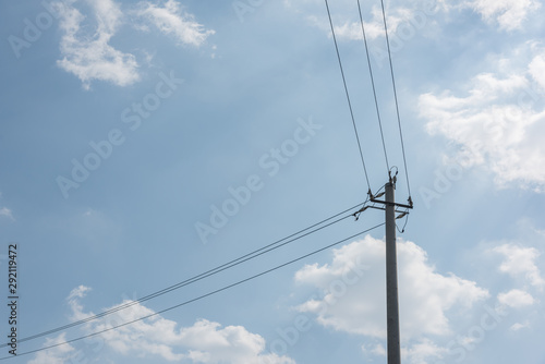 Close-up of concrete cement poles and wires against sky clouds background