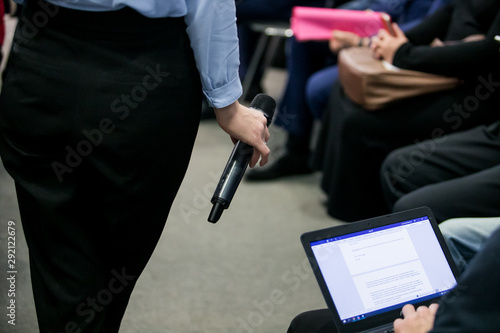 Press officer of a company giving interview to journalist with a microphone photo