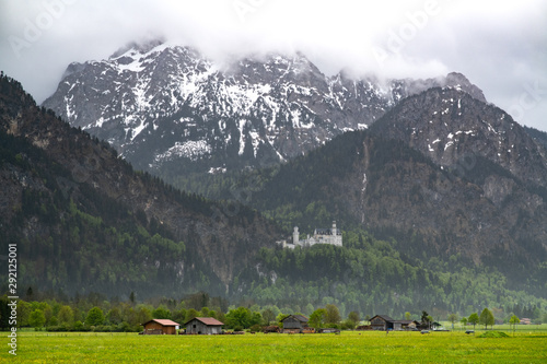 Neuschwanstein castle on the mountain of Bavarian apls with forground of green meadow during spring season in Schwangau, Germany.