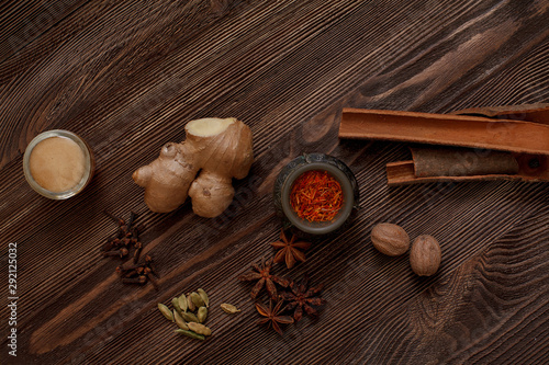 Spices for Masala tea are on the brown wooden table