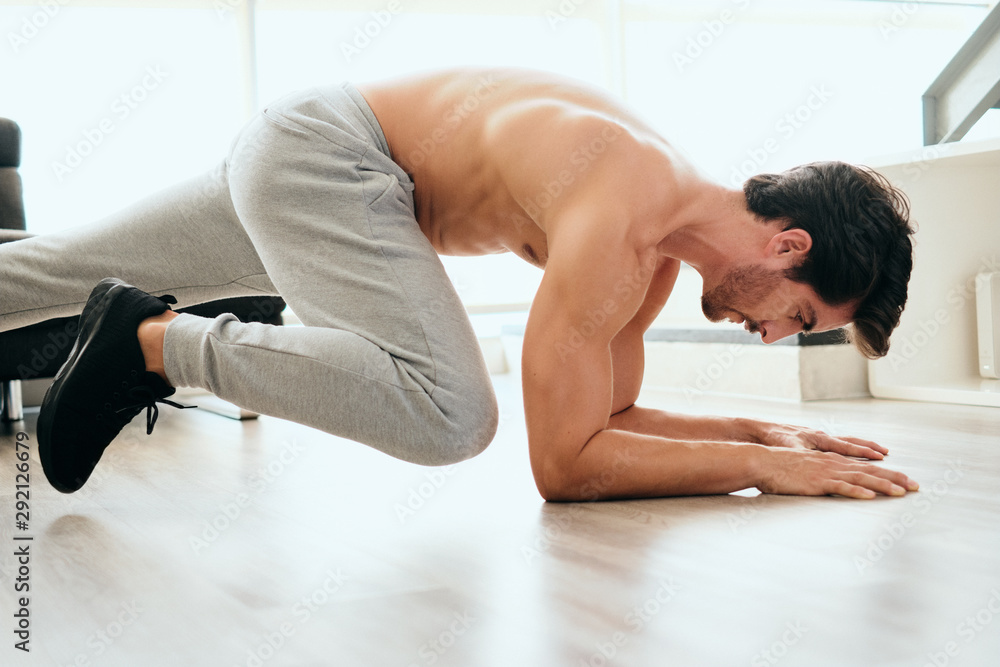 Obraz premium Adult Man Training ABS and Legs Doing Mountain Climbing Plank