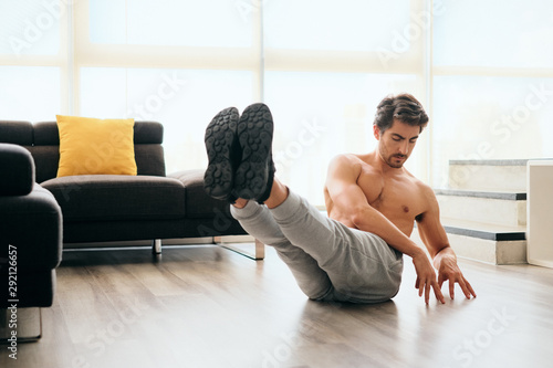 Adult Man Training ABS Muscles At Home Doing Russian Twist Exercise