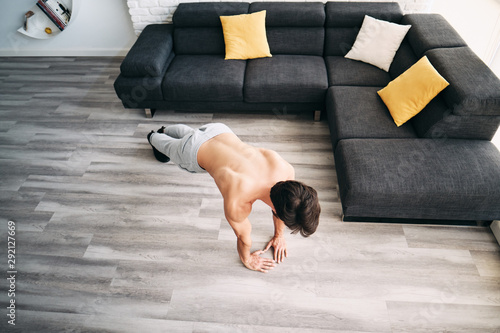 Fotografija Adult Man Training Chest Muscles At Home Doing Push-Ups
