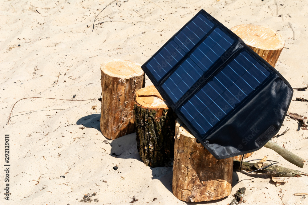 Portable solar panels lie on an wood and accumulate energy. Portable solar panels lie on an wood and accumulate energy.