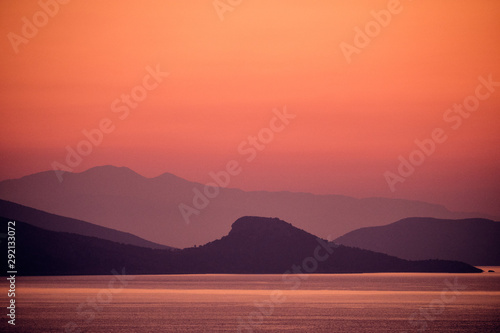 sunset with mountains on sea