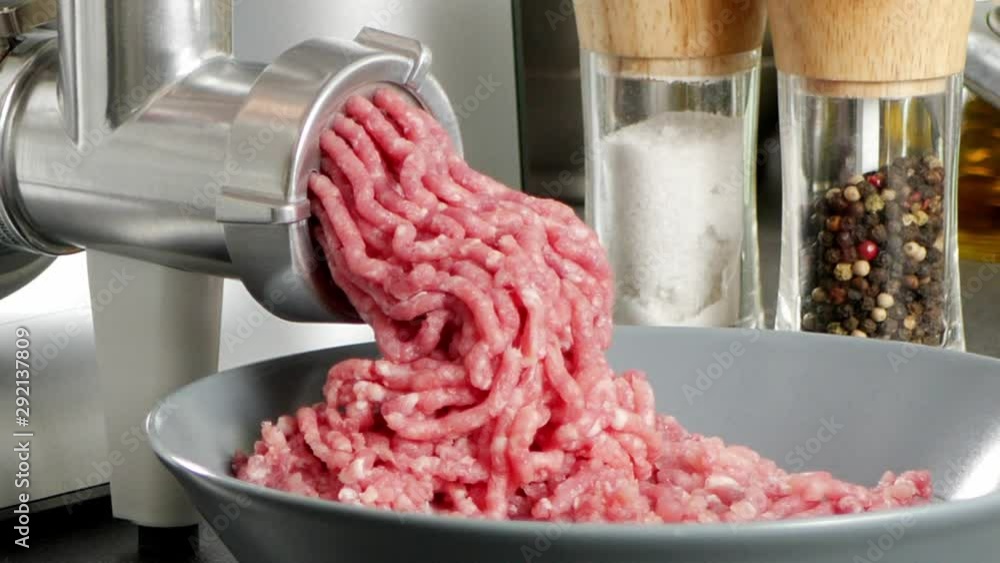 Grinding meat in a food processor. Close up of the machine. Grinding meat in a food processor. Close up of the machine.