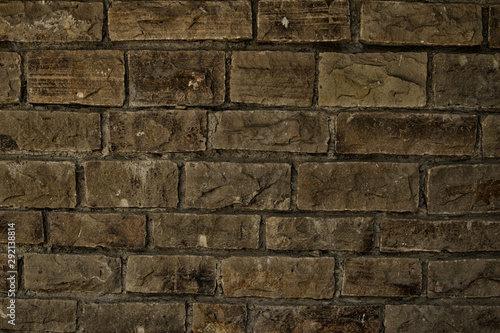 Dark wall of stone grey bricks, abstract background. Brick wall building