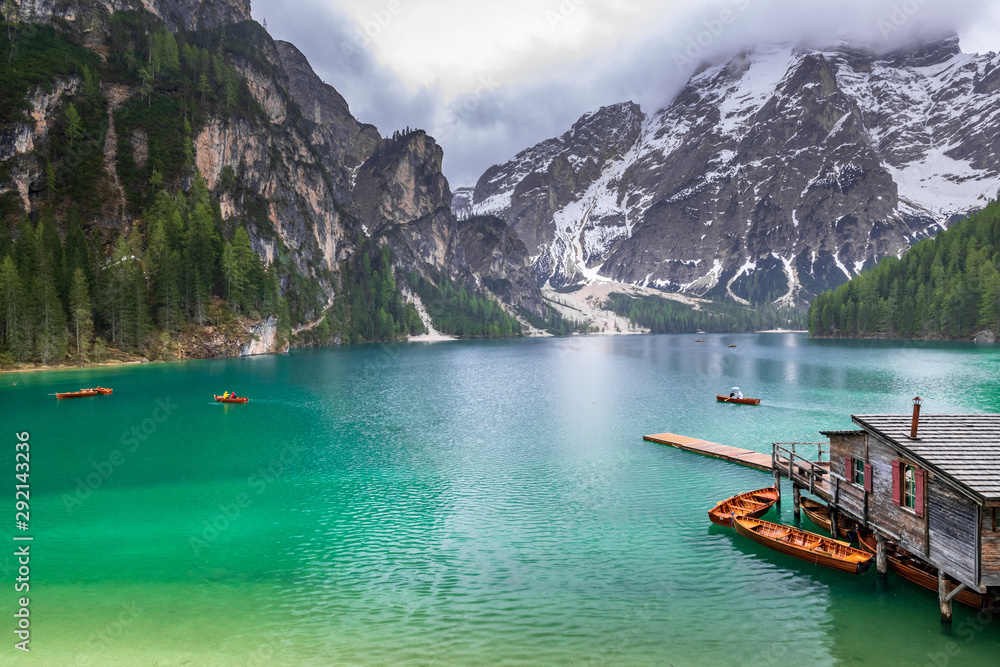 A tourist enjoy boating at Braies lake in Dolomites, Italy. A turquoise lake with background of mountains of alps.