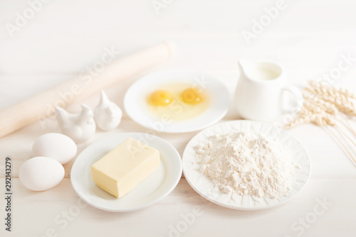 flour, eggs, butter and milk on a white wooden background, ingredients for baking