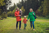 family walking in autumn forest. candid portrait of happy parents and kids.