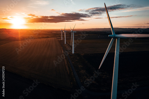 Aerial of wind turbines at sunrise in the English countryside with a dramatic sky