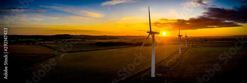 Aerial of wind turbines at sunrise in the English countryside with a dramatic sky panoramic