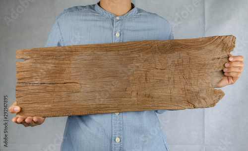 Close up hand holding wood for  Blank billboard design on the wood wall.