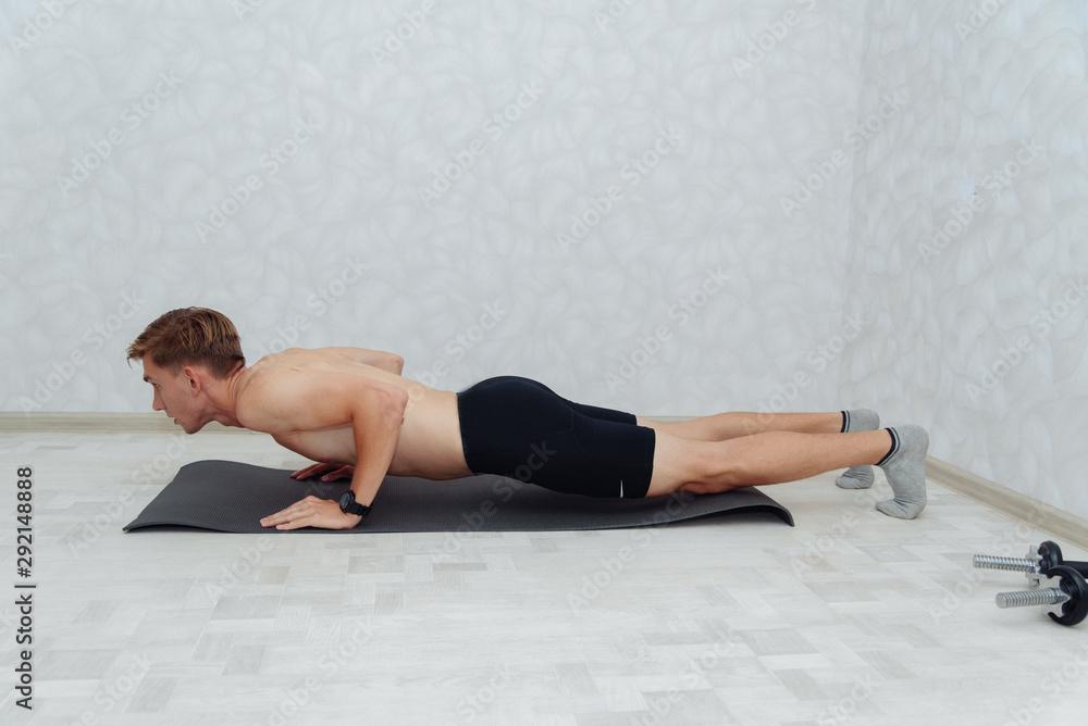 handsome man doing push ups in bright living room handsome man doing push ups in bright living room