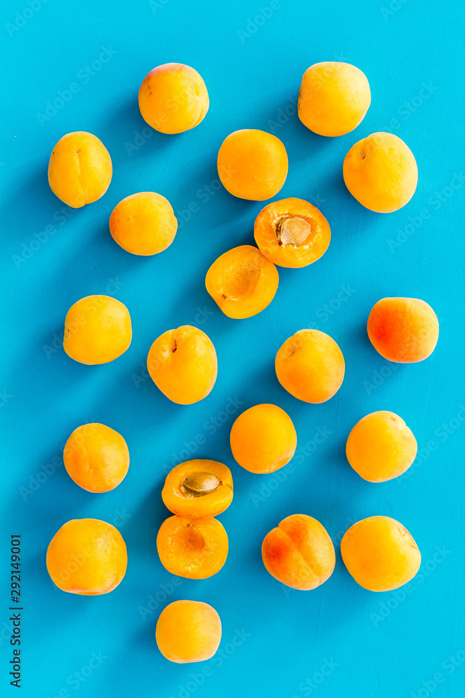 Apricots pattern on blue background top view