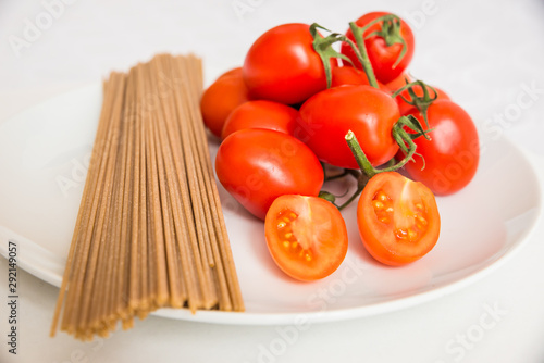 spaghetti integrali, pomodori, ingredienti per la pasta al pomodoro