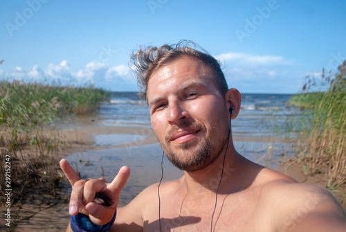 Funny guy takes selfie on Ladoga lake beach, photo