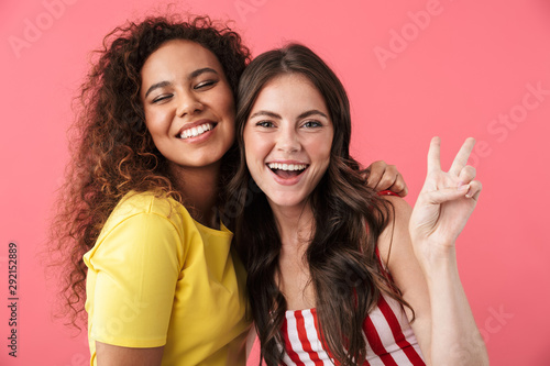 Image of brunette multinational girls smiling together at camera