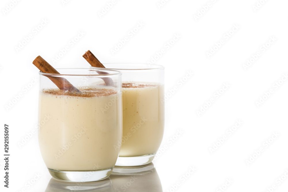 Homemade eggnog with cinnamon in glass isolated on white background. Typical Christmas dessert.Copy space Homemade eggnog with cinnamon in glass isolated on white background. Typical Christmas dessert.Copy space