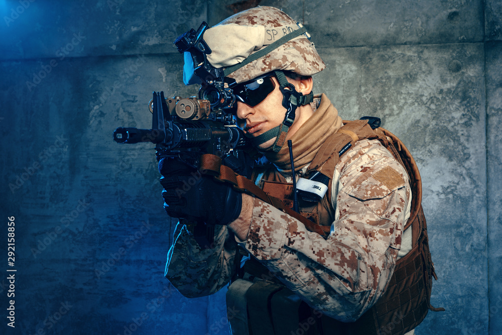 American private military contractor shooting a rifle. Studio shot American private military contractor shooting a rifle. Studio shot